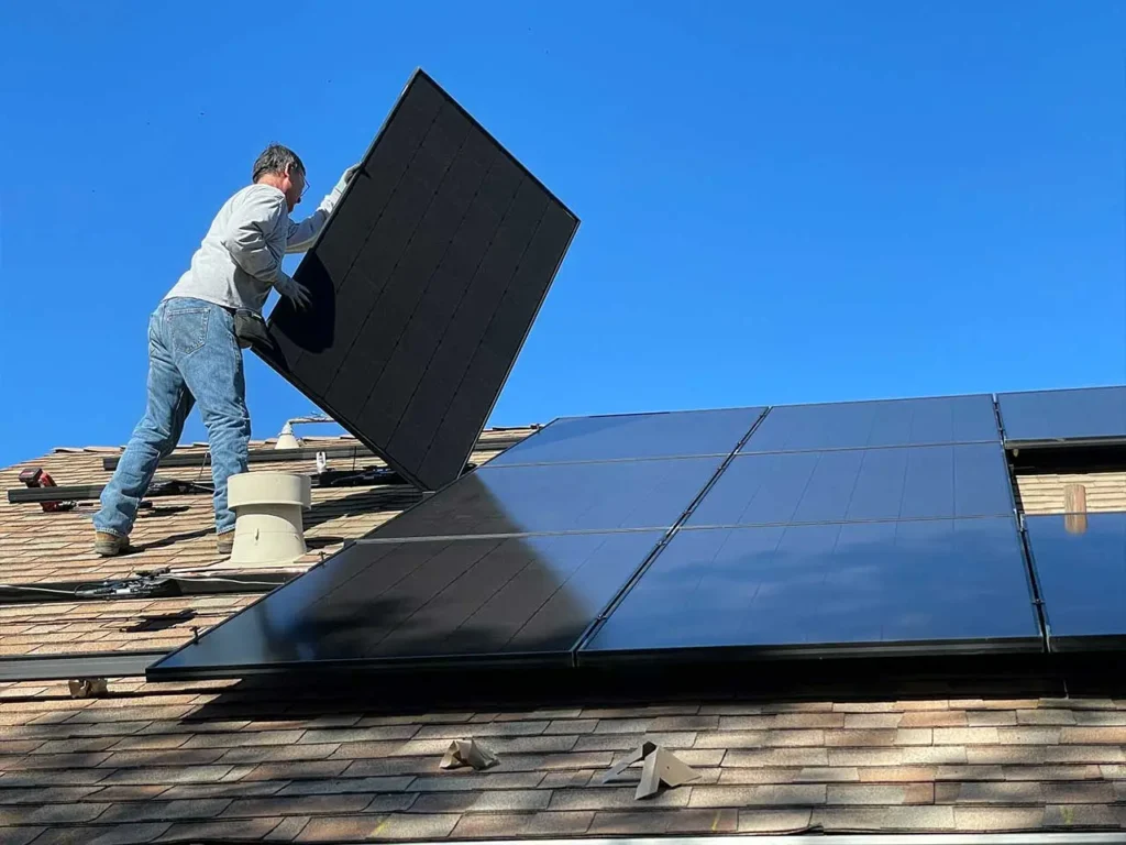 Mann installiert PV-Anlage auf Dach