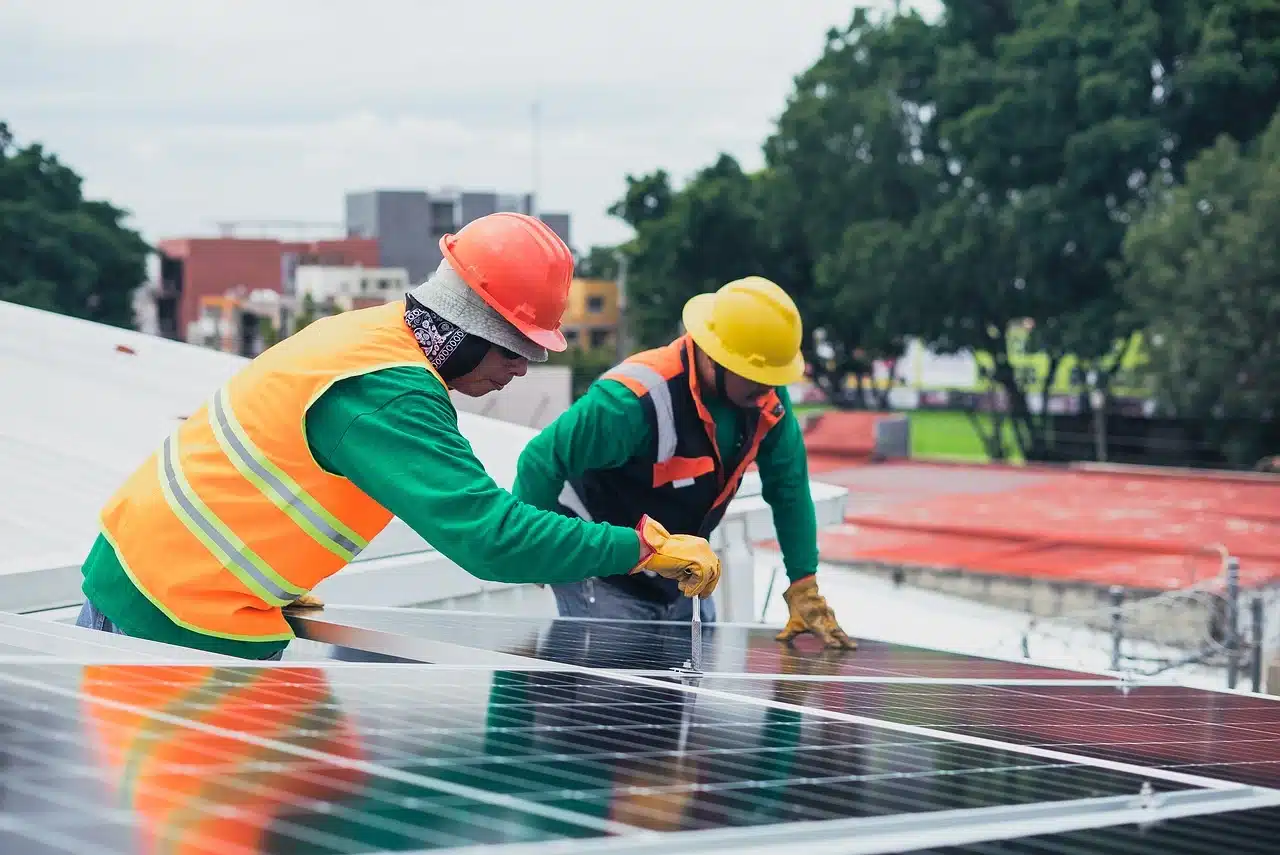 Bauarbeiter installieren ein Solarpaneel.