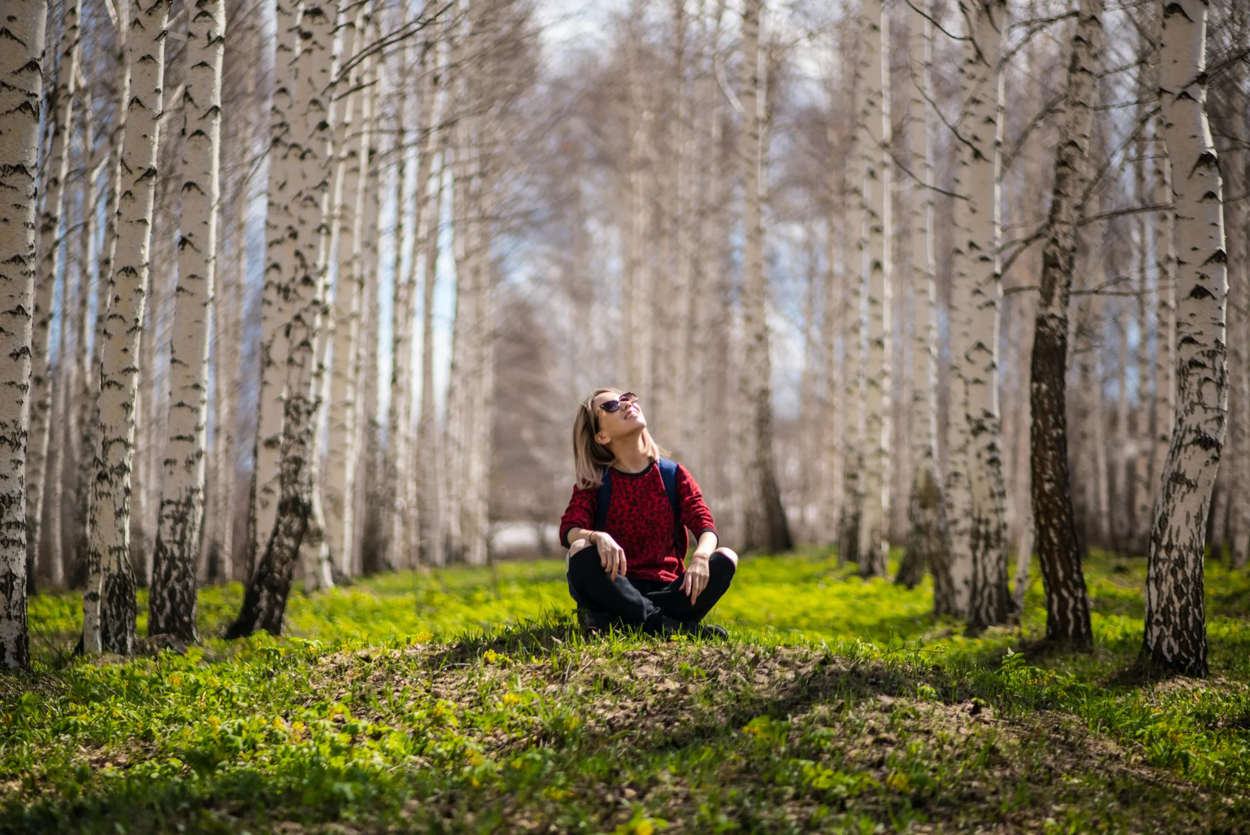 Eine Frau sitzt in einem Wald (Foto: Pexels)