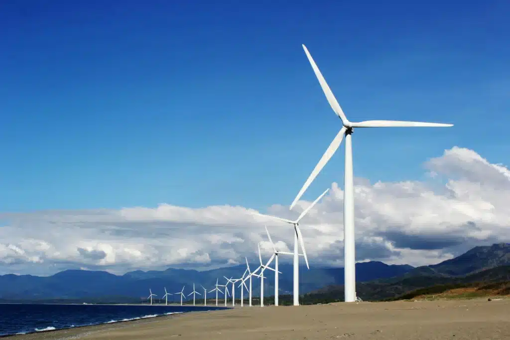 Windmühlen stehen in einer Reihe vor blauem Himmel mit einigen Wolken. (Foto: Kervin Edward Lara/Pexels)