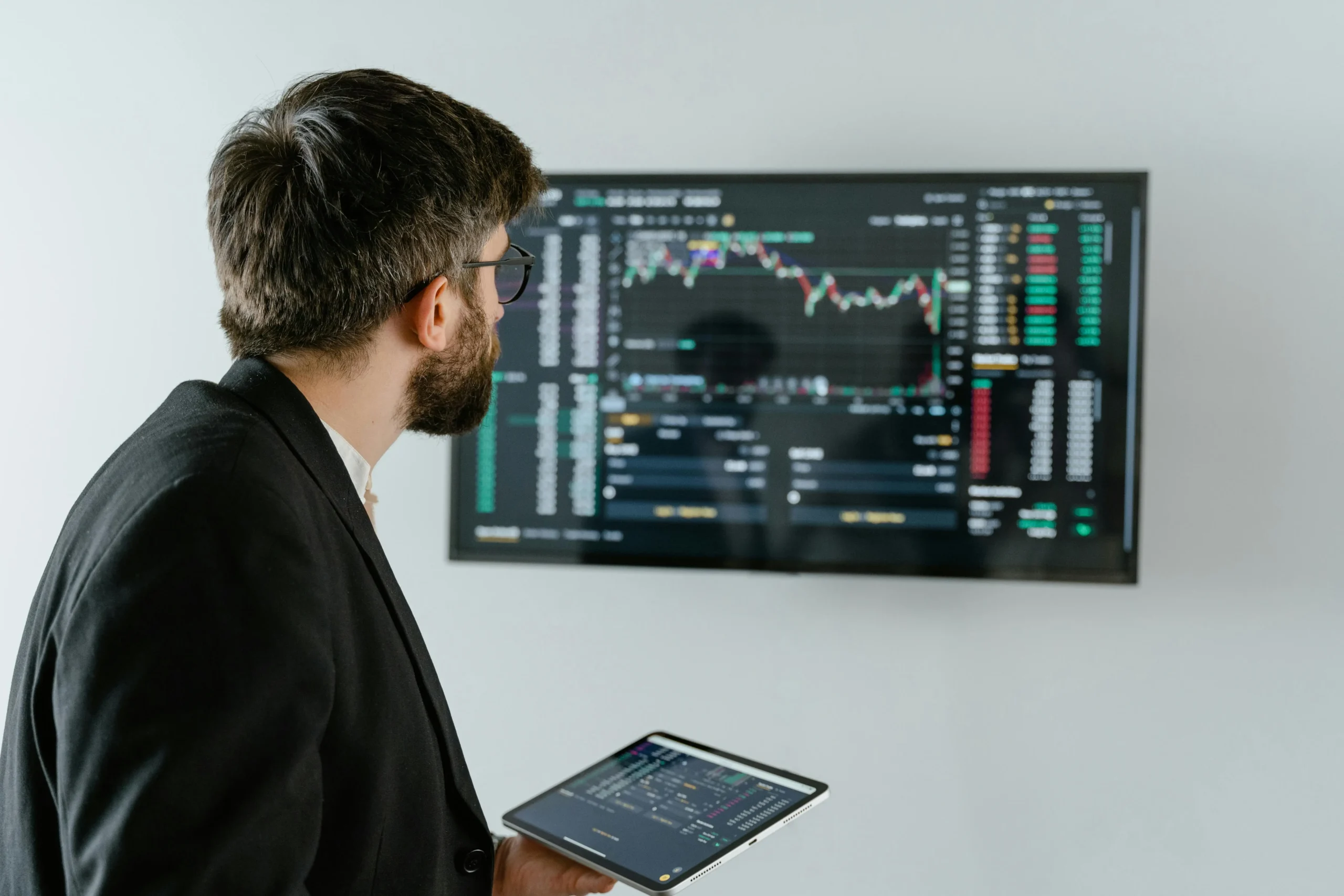 Ein Mann schaut sich digitale Investments auf einem Bildschirm an. (Foto: Pexels)