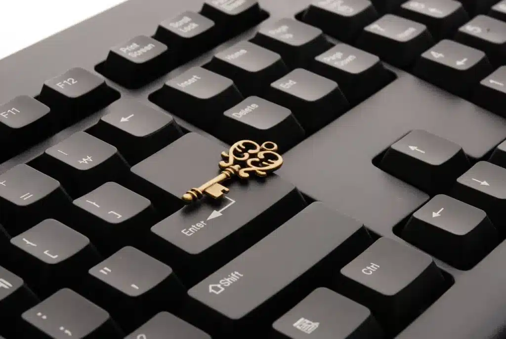 Ein alter Messingschlüssel liegt auf den schwarzen Tasten einer Computertastatur und symbolisiert den Sicherheitscheck, wobei der Schlüssel quer über die Enter- und die Umschalttaste gelegt ist.