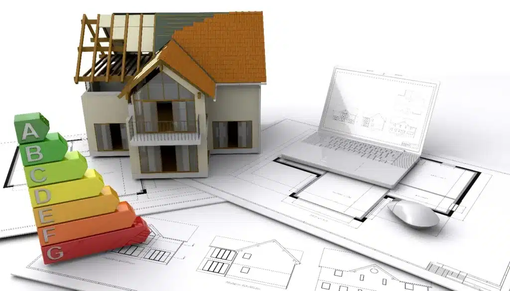 Ein Modellhaus, eine Energieeffizienz-Tabelle, ein geöffneter Laptop und architektonische Baupläne sind nebeneinander angeordnet und symbolisieren Hausgestaltung, Planung und Energieeffizienz – ideal, um Themen wie energetische Sanierung oder die Beantragung von Fördermitteln zu erkunden.
