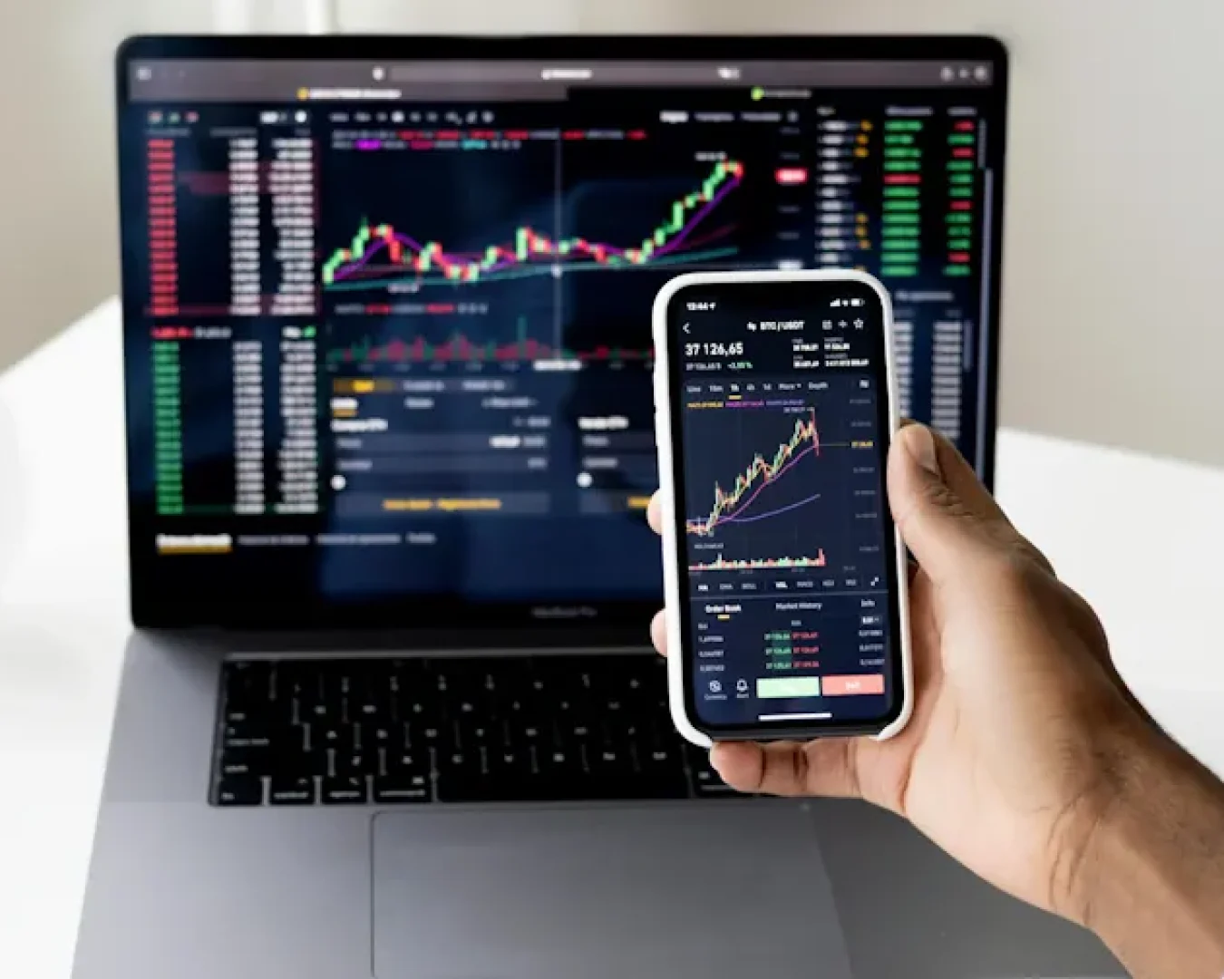 Laptop und Handy zeigen eine Aktienentwicklung. (Foto: Anna Nekrashevich/Pexels)