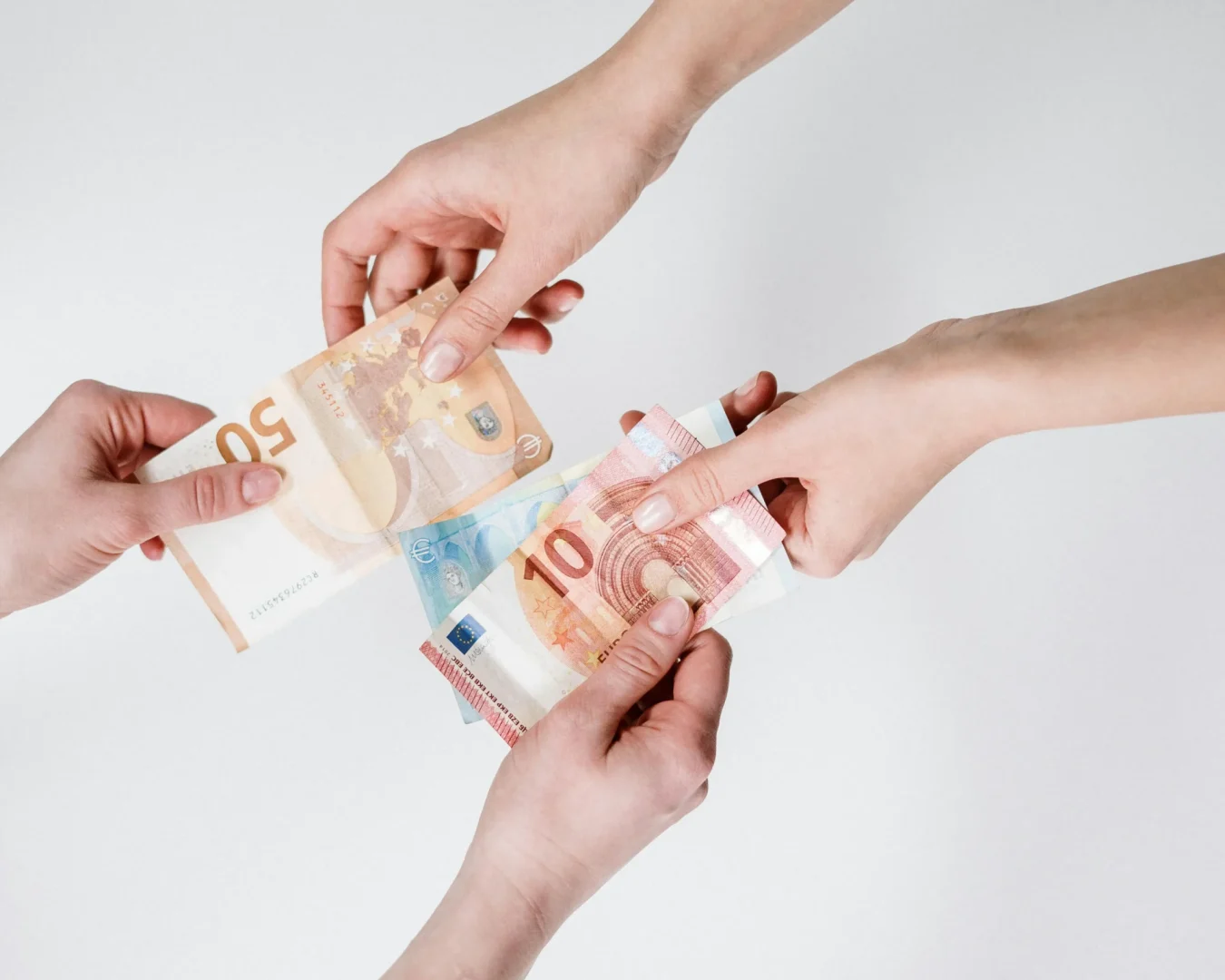 Zwei paar Hände halten Geldscheine. (Foto: Pexels)